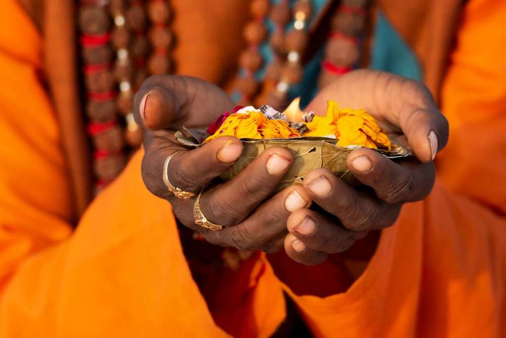 Holy man in Varanasi holding flowers.